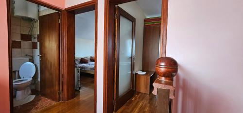 a bathroom with a toilet and a door to a bedroom at Holiday house and apartments Vale in Duga Resa
