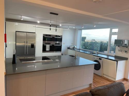 a kitchen with stainless steel appliances and a large window at Dog friendly, Roof top hot tub, Panoramic views. in Torquay
