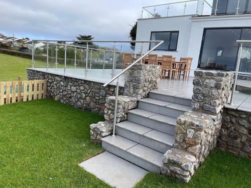 a stone house with a staircase and a patio at Dog friendly, Roof top hot tub, Panoramic views. in Torquay