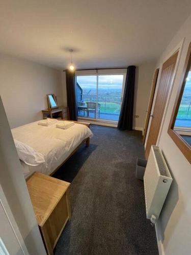 a bedroom with a bed and a view of the ocean at Dog friendly, Roof top hot tub, Panoramic views. in Torquay