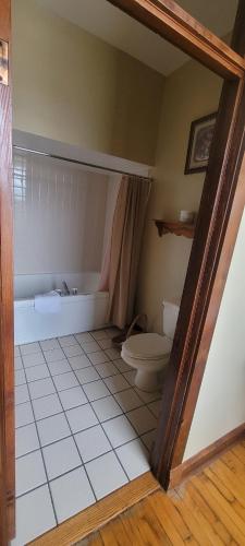 ein Bad mit einer Badewanne und einem WC. in der Unterkunft Karsten Hotel in Kewaunee