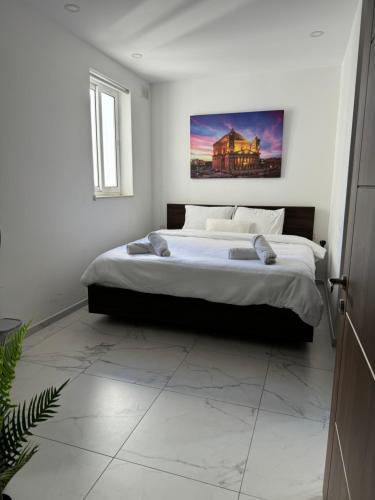 1 dormitorio con 1 cama grande y una pintura en la pared en Designer 3 Bedroom / Bathroom Apartment in Swatar., en Birkirkara