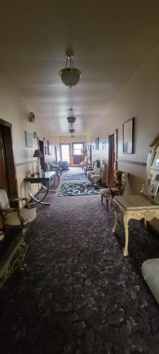 ein leeres Zimmer mit Tischen und Stühlen in einem Gebäude in der Unterkunft Karsten Hotel in Kewaunee