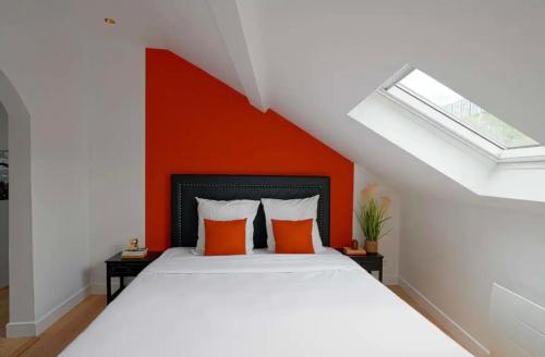 1 dormitorio con 1 cama con pared de color naranja en Suite Savanah, en Lyon