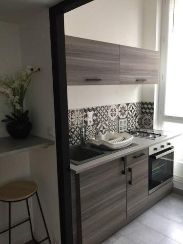 une cuisine avec un évier et une cuisinière dans l'établissement Appart au centre ville avec parking privé et wifi, à Auxerre