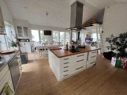 eine Küche mit einer großen Insel in der Mitte in der Unterkunft Härlig Skärgårdsvilla med strålande sjöutsikt in Dalarö