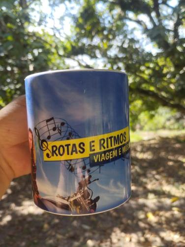 a person holding a cup with a picture on it at Pousada rotas e ritmos in Sao Paulo