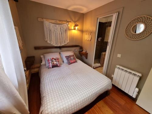 Un dormitorio con una cama con almohadas. en Petite chambre cosy avec salle de bain privative, en Saint-Pierre-dels-Forcats