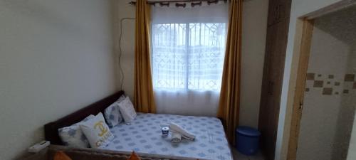 - une petite chambre avec un lit et une fenêtre dans l'établissement Luca Homes Studio Apartment, à Mombasa