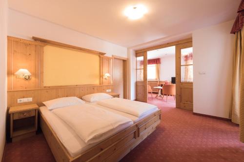 a bedroom with a large bed in a room at Berghotel zum Zirm in Collalbo