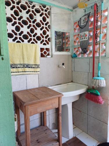 a bathroom with a sink and a table in it at Recanto Figueira Silvestre in Cidreira