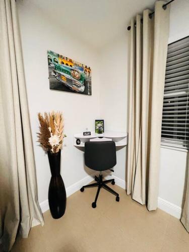 a desk with a vase and a chair in a room at Casita Cafe in Miami