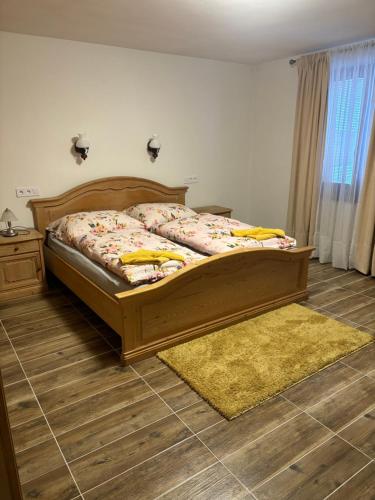 a bedroom with a wooden bed with a yellow rug at Chata u Miťa in Telgárt