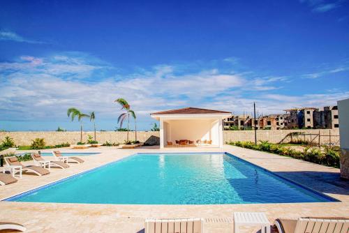 a swimming pool with chairs and a gazebo at Beautiful Village 3 bedrooms Furnished Pool residencial Velero punta cana in Punta Cana