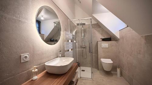 a bathroom with a sink and a toilet and a mirror at Maison au cœur de la forêt 