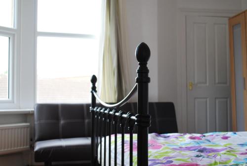 a bedroom with a bed and a couch and a window at Clift Guest House in Bristol
