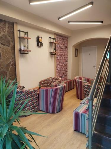a waiting room with couches and a stair case at UB Prenociste in Vranjska Banja