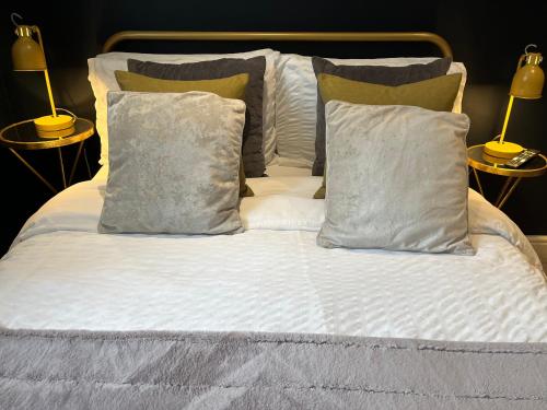 a bed with white sheets and pillows and two lamps at The Old Farmhouse in Bristol