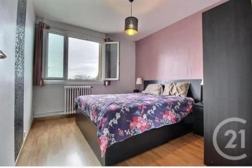 um quarto com uma cama e uma parede rosa em Très charmant appartement proche de Paris em Aulnay-sous-Bois