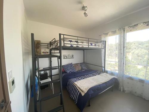 une chambre avec deux lits superposés et une fenêtre dans l'établissement Domaine Arca appartement 6 à 8 Personnes, à Porto-Vecchio