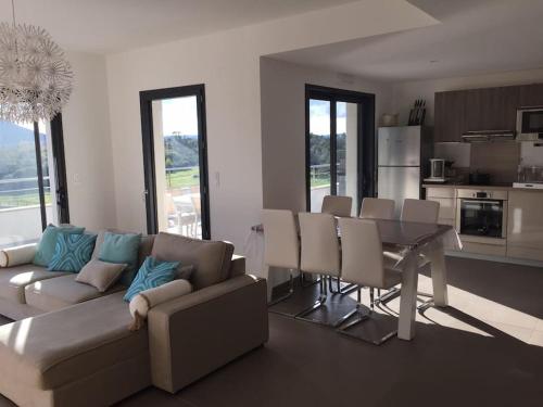 un salon avec un canapé et une table avec des chaises dans l'établissement Domaine Arca appartement 6 à 8 Personnes, à Porto-Vecchio