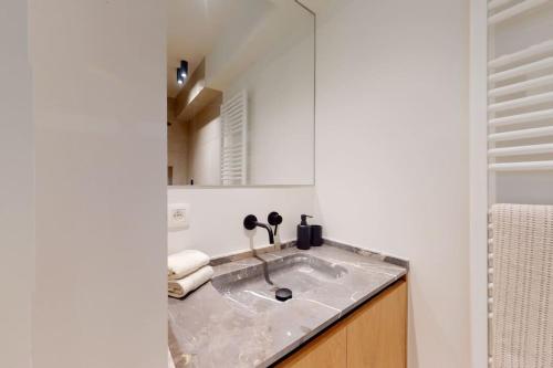 a bathroom with a sink and a mirror at Lush 3bed/3bath penthouse w deck in Knokke-Heist