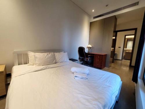 una camera con un grande letto bianco e una scrivania di The Rixx Simple Apartment @ Marq/pool/gym/Netflix ad Ho Chi Minh