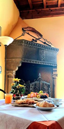 a table with plates of food in front of a fireplace at Agriturismo Villa Guarnaschelli in Scandicci