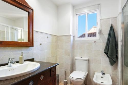 W łazience znajduje się umywalka, toaleta i lustro. w obiekcie NT Centro Ciudad - Catedral & Parking w Maladze