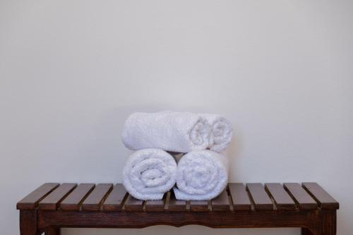 uma pilha de toalhas sentadas em cima de um banco de madeira em Billy's House em Samos