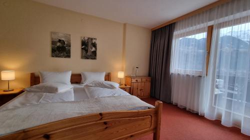 a bedroom with two beds and a large window at Haus Alpenglühn in Sautens