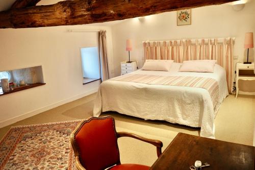 a bedroom with a bed and a table and a chair at Logis du paradis in Criteuil-la-Magdeleine