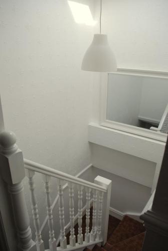 a white staircase with a lamp and a mirror at Clift Guest House in Bristol