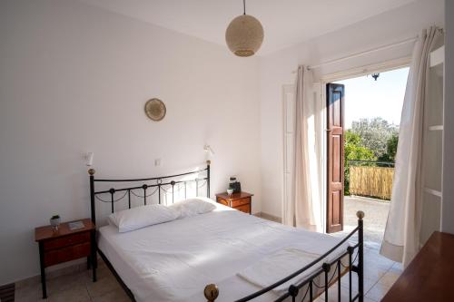 a bedroom with a bed and a door to a patio at Billy's House in Samos