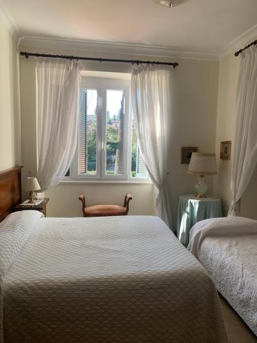 a bedroom with two beds and a window at Villa Orsini in Tor Vergata
