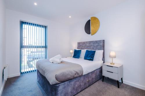 a bedroom with a large bed and a window at Axium Suite- Modern 2 bed in Birmingham City Centre- Perfect for Business, Family and Leisure Stays in Birmingham