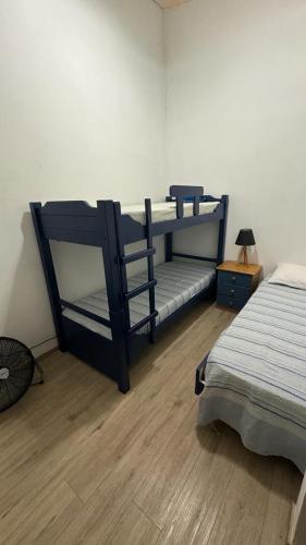 a bedroom with two bunk beds and a wooden floor at Las Ranitas in Parque del Plata