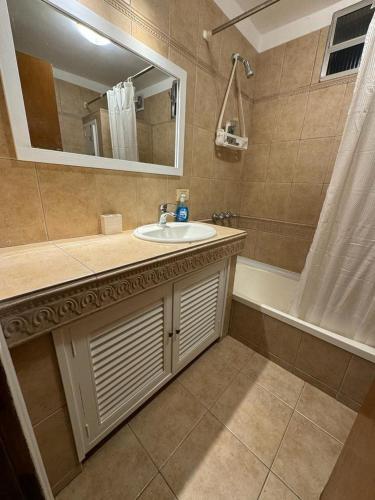a bathroom with a sink and a mirror and a tub at Las Ranitas in Parque del Plata