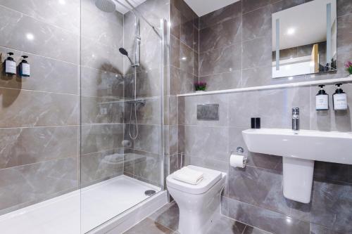 a bathroom with a shower and a toilet and a sink at Sterling Suite - Modern 2 Bedroom Apartment in Birmingham City Centre - Perfect for Family, Business and Leisure Stays by Dreamluxe in Birmingham