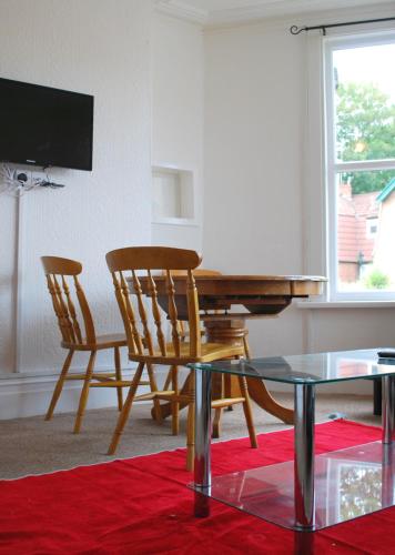a living room with a piano and two chairs and a table at Clift Guest House in Bristol