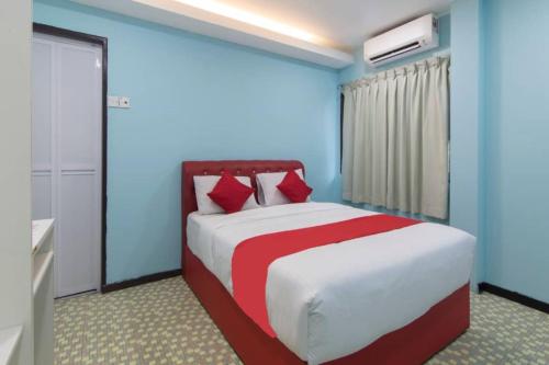 a bedroom with a large bed with blue walls and red accents at Star Hotel in Port Dickson