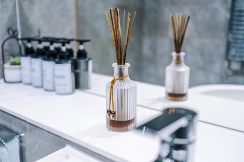 a bathroom counter with two vases with reeds in it at Axium Suite- Modern 2 bed in Birmingham City Centre- Perfect for Business, Family and Leisure Stays in Birmingham