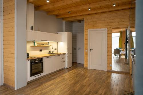 a kitchen with white cabinets and a wooden floor at Шале Green Land in Bukovel