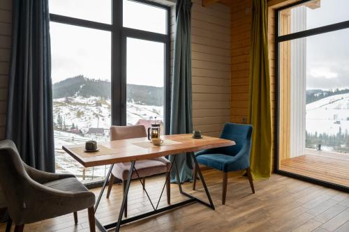 a table and chairs in a room with a large window at Шале Green Land in Bukovel