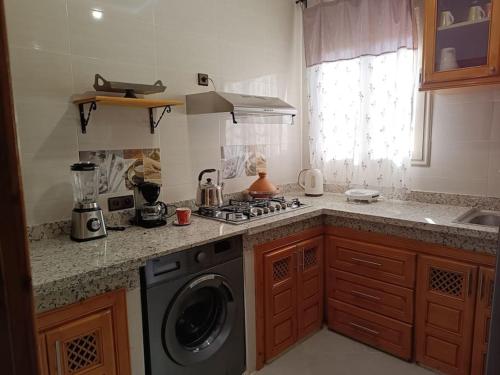 Il comprend une cuisine équipée d'une cuisinière et d'un lave-linge. dans l'établissement Oasis appart sérénité, à Marrakech