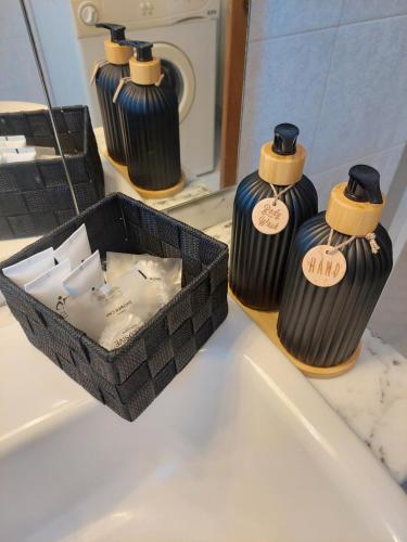 three black vases sitting on a bathroom sink with a box at Rosa d' Inverno in Piancastagnaio