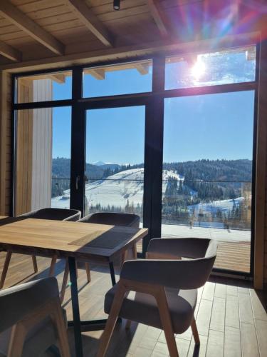 a room with a table and chairs and a large window at Шале Green Land in Bukovel