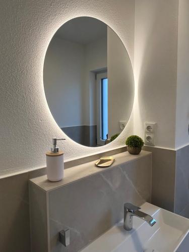 a bathroom with a sink and a mirror at UNiQE I 90qm I Bergblick I 3 Balkone I seenah in Prien am Chiemsee