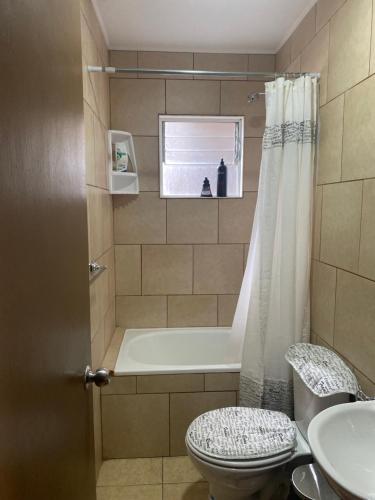 een badkamer met een bad, een toilet en een wastafel bij victoria in Porvenir