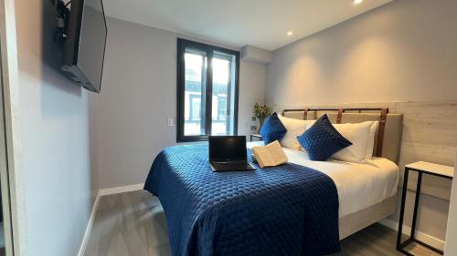 a bedroom with a bed with a laptop on a blue blanket at Wellington Temple Bar in Dublin